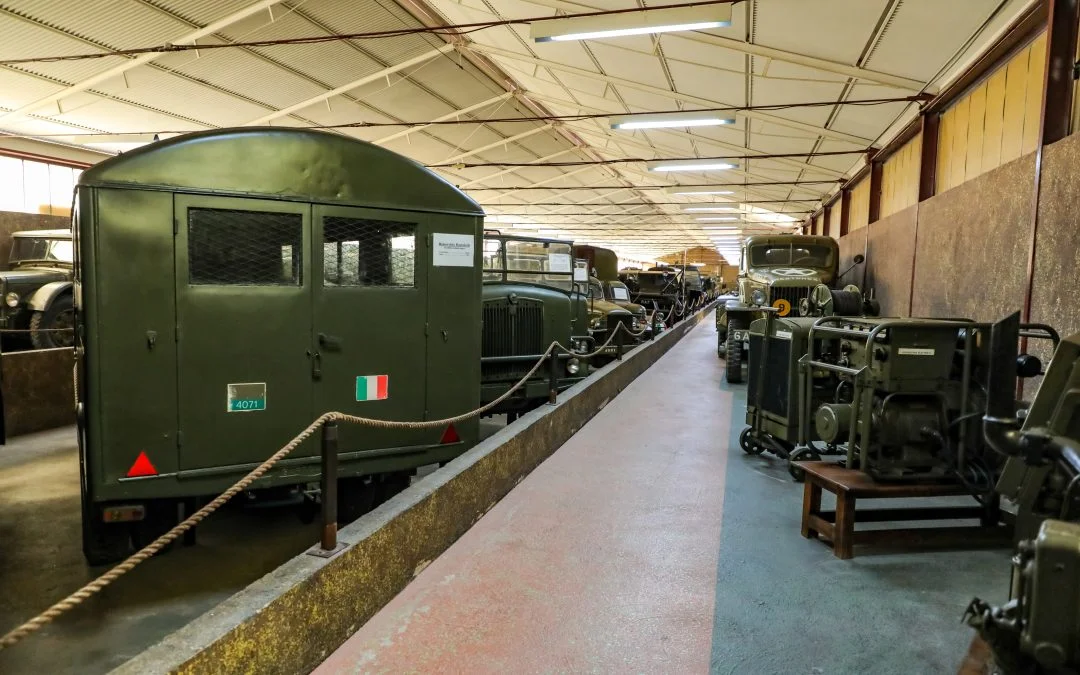 Historic military vehicles displayed inside the Piana delle Orme museum gallery.